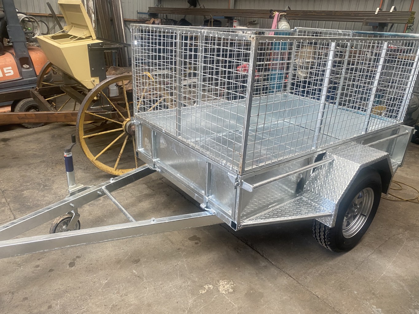 Small trailer manufactured to include cage
